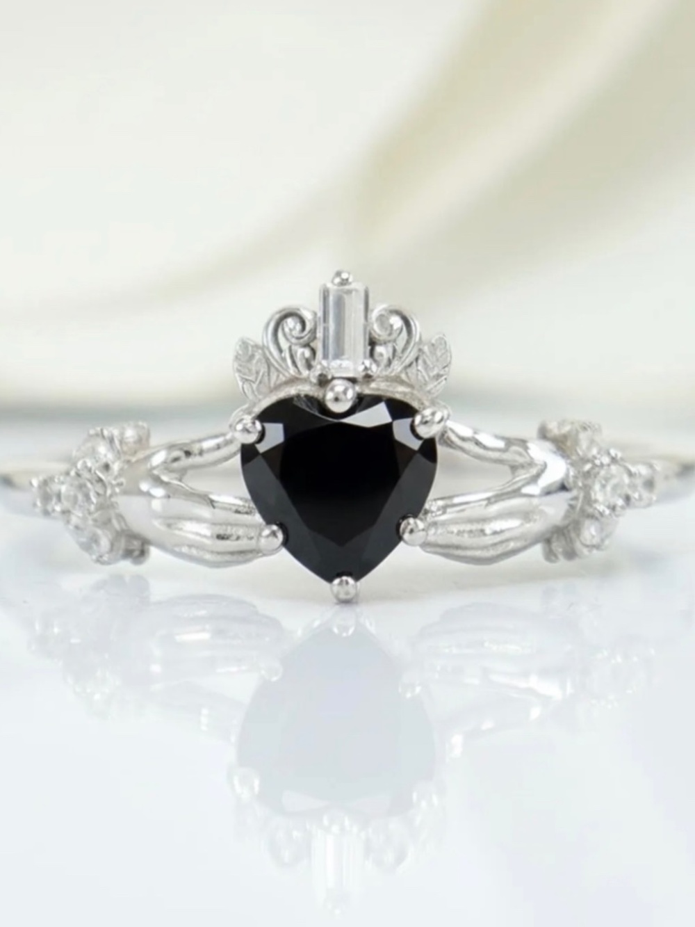 traditional silver-toned Claddagh ring featuring a black heart-shaped center